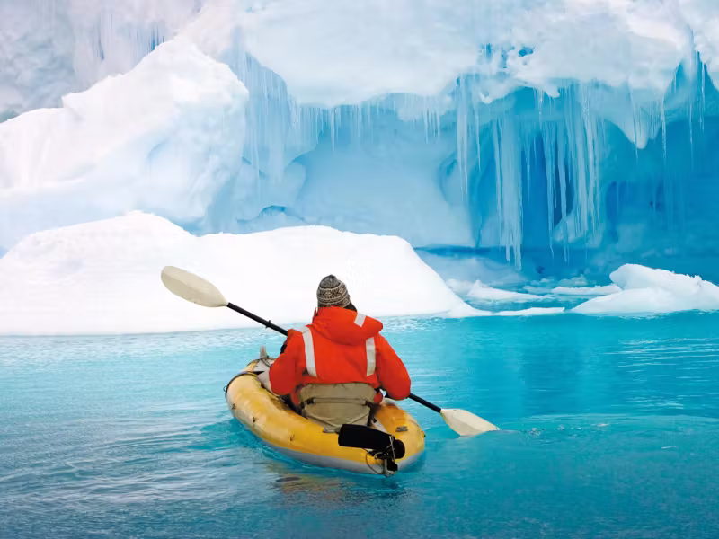 NG - Antarctica Boat Cruises Testimonials - man-on-kayak-close-up-in-ice-water